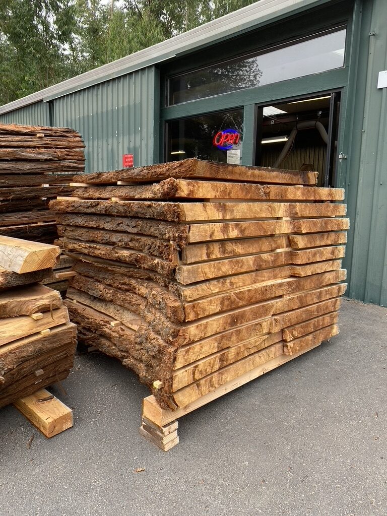 Live edge slab stacks outside the shop